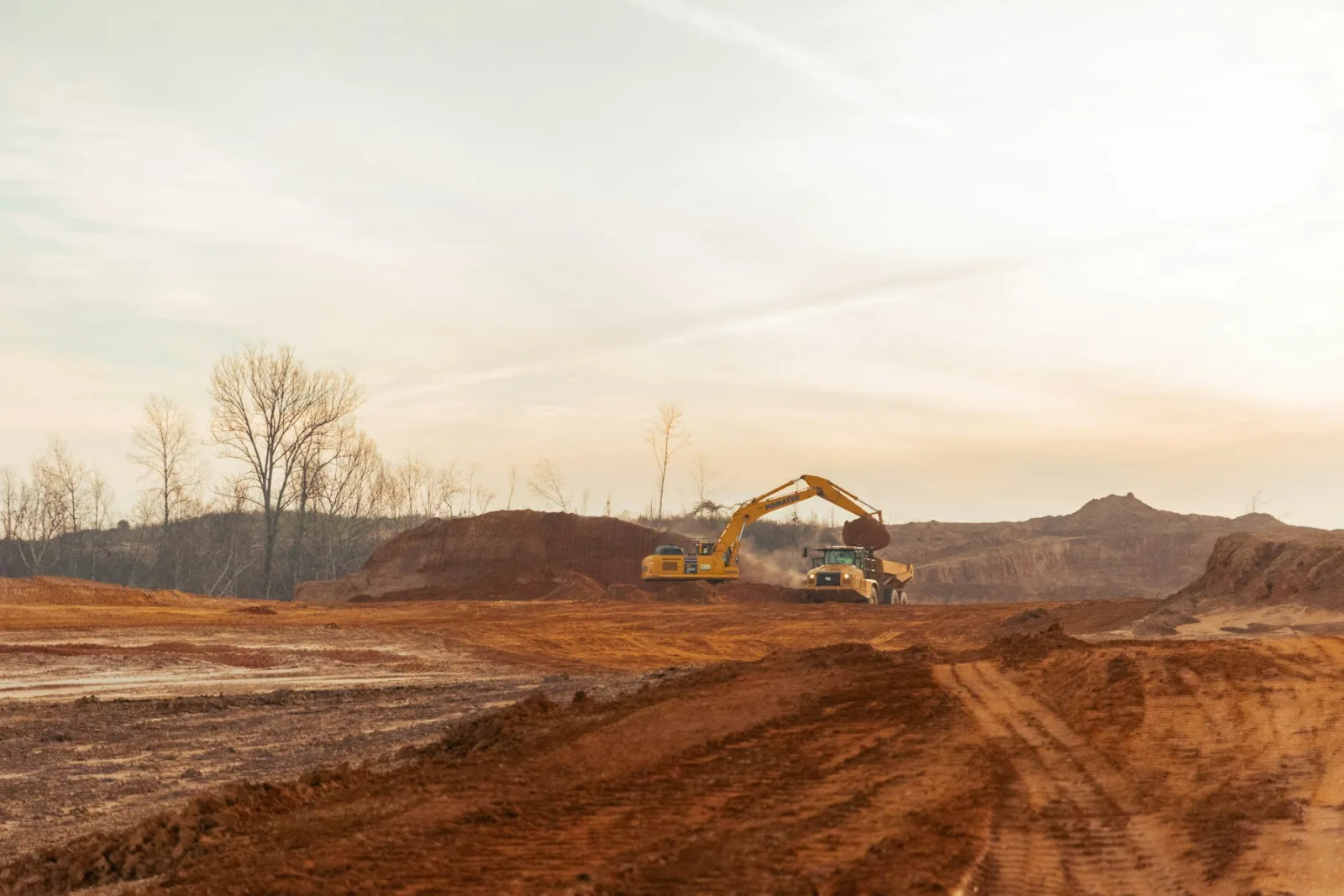 Bagger verlädt Erdaushub auf einer Baustelle
