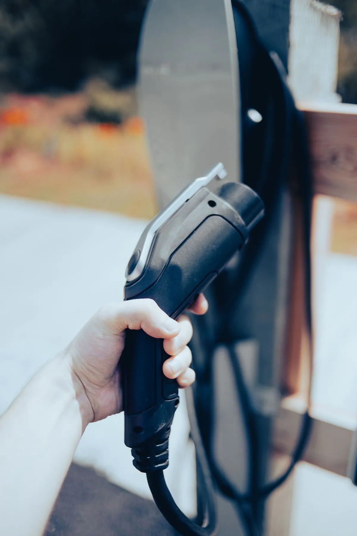 Hand hält einen Ladestecker für Elektrofahrzeuge