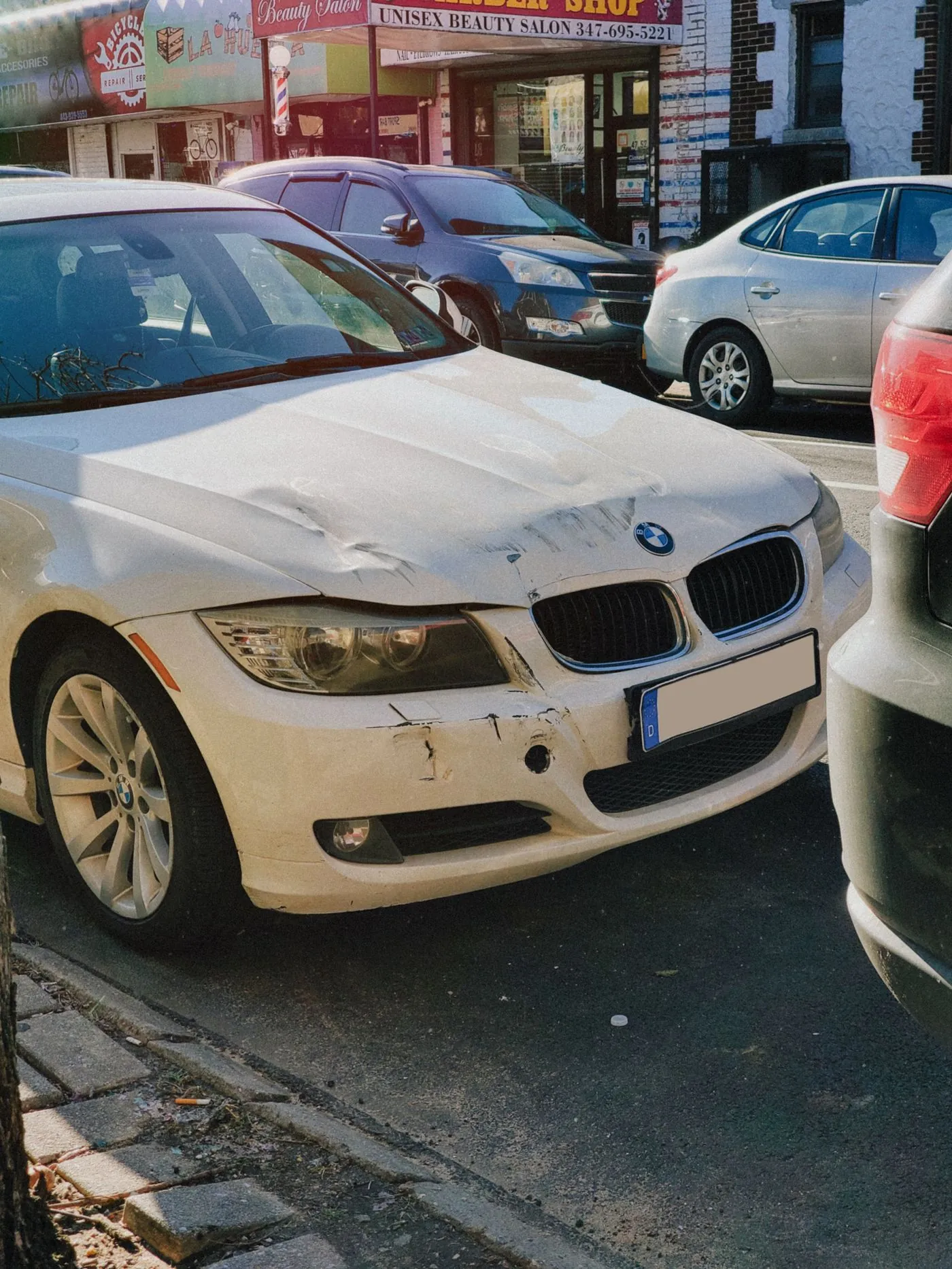 Weiße Limousine mit eingedrückter Front nach einem Unfall