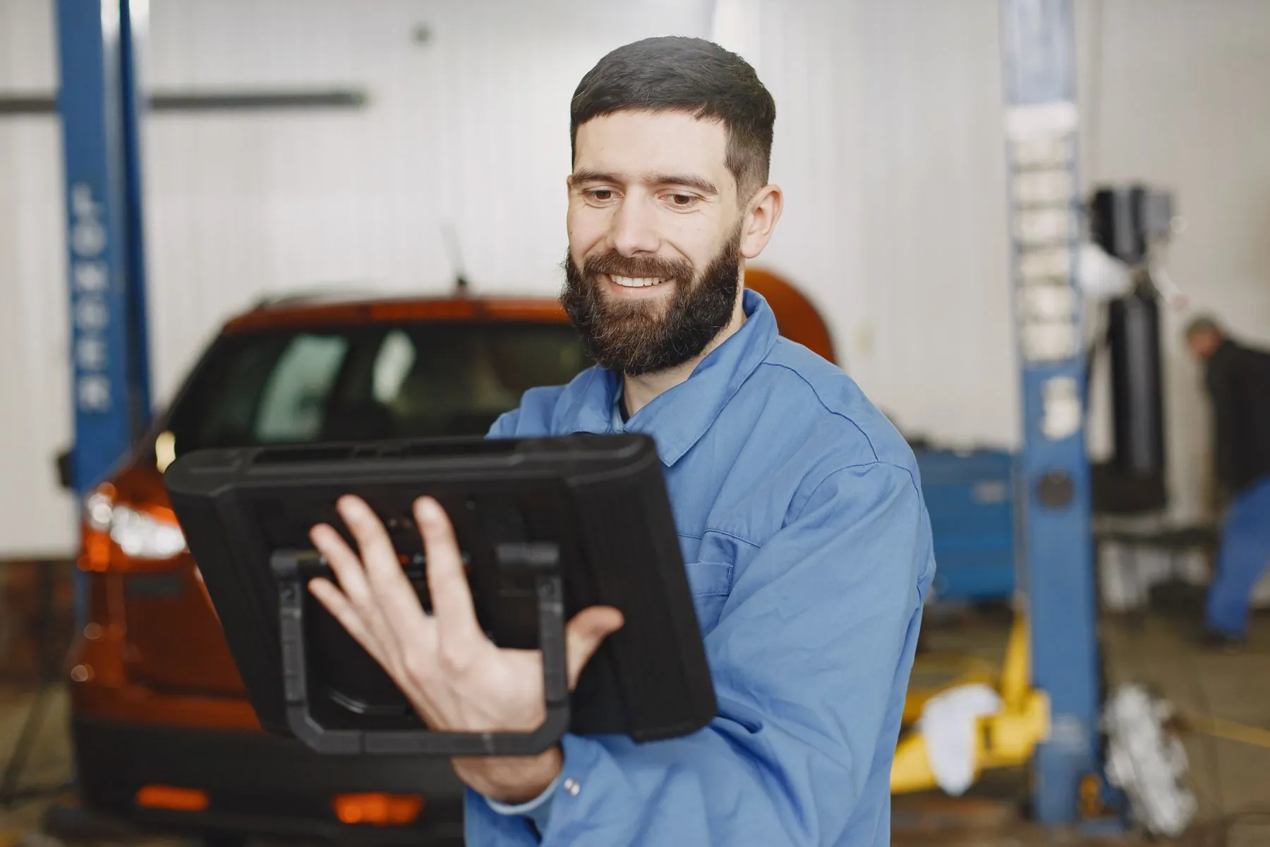 Sachverständiger mit Tablet in einer Werkstatt