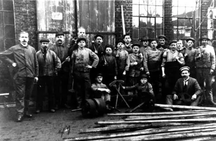 Historisches Gruppenfoto der Belegschaft vor der Werkstatt
