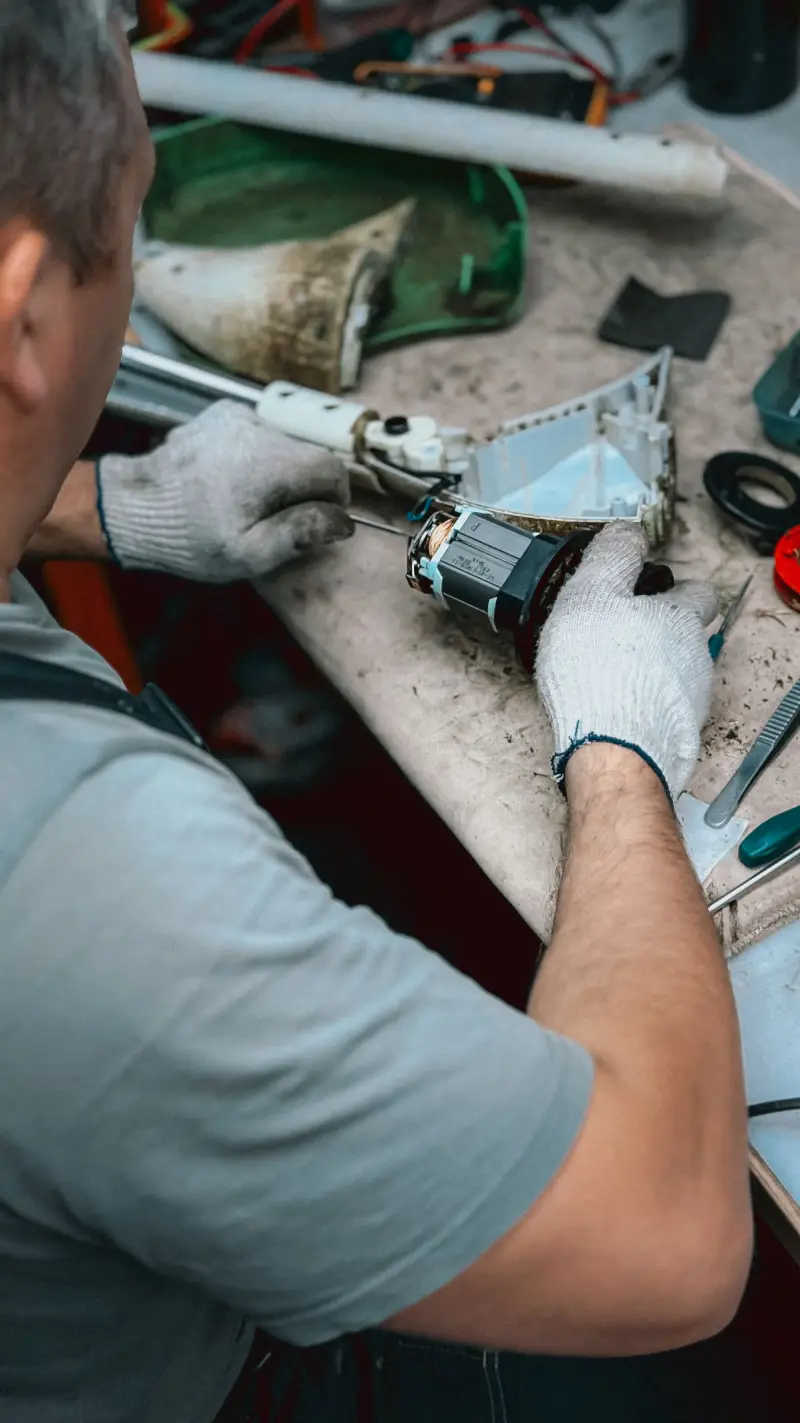 Techniker mit Handschuhen repariert ein Gerät