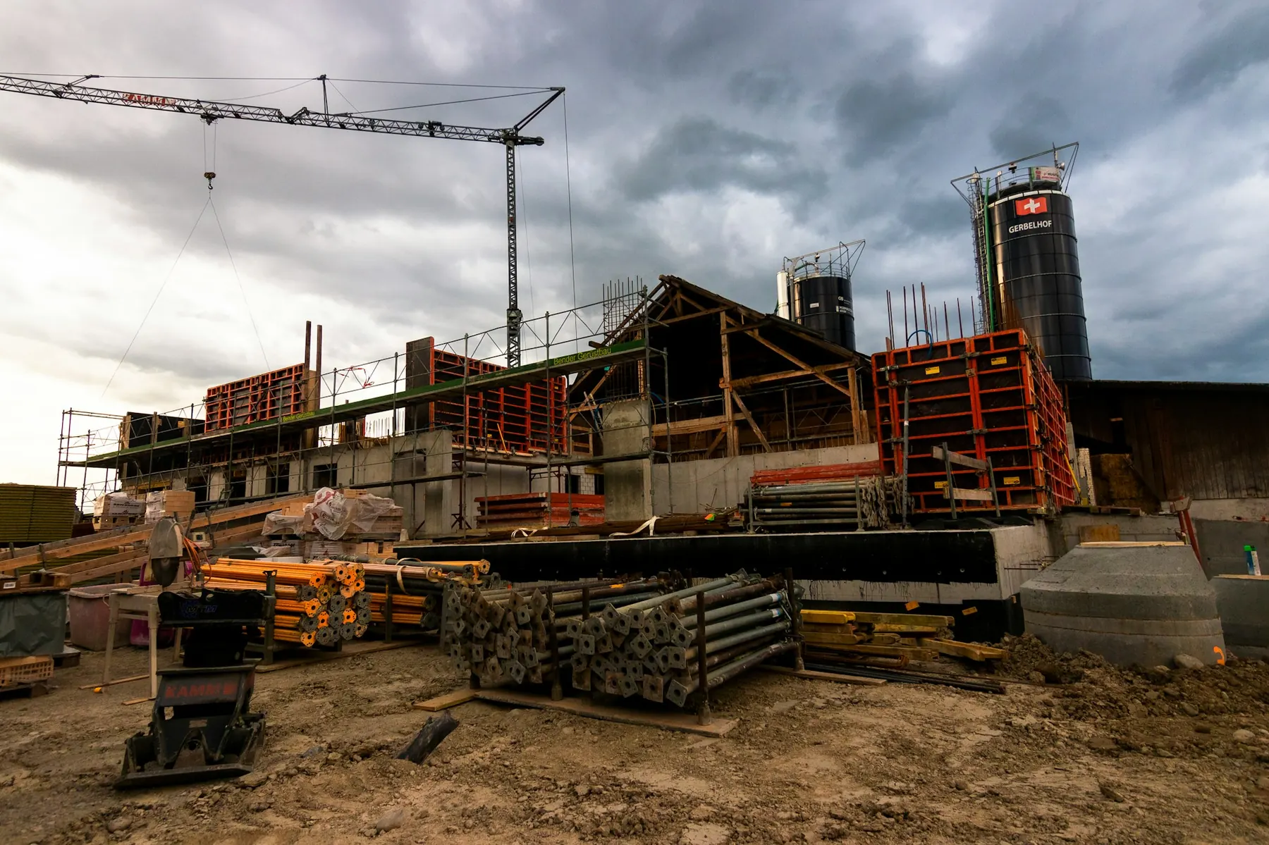Rohbau mit Kran, Schalung und Baumaterial