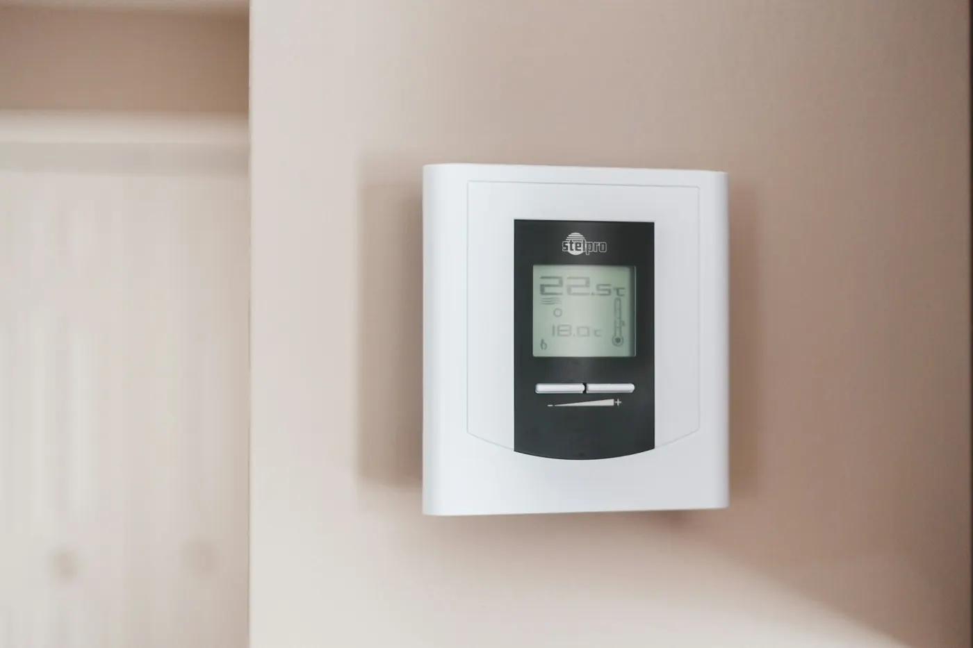 Digitales Raumthermostat an einer hellen Wand