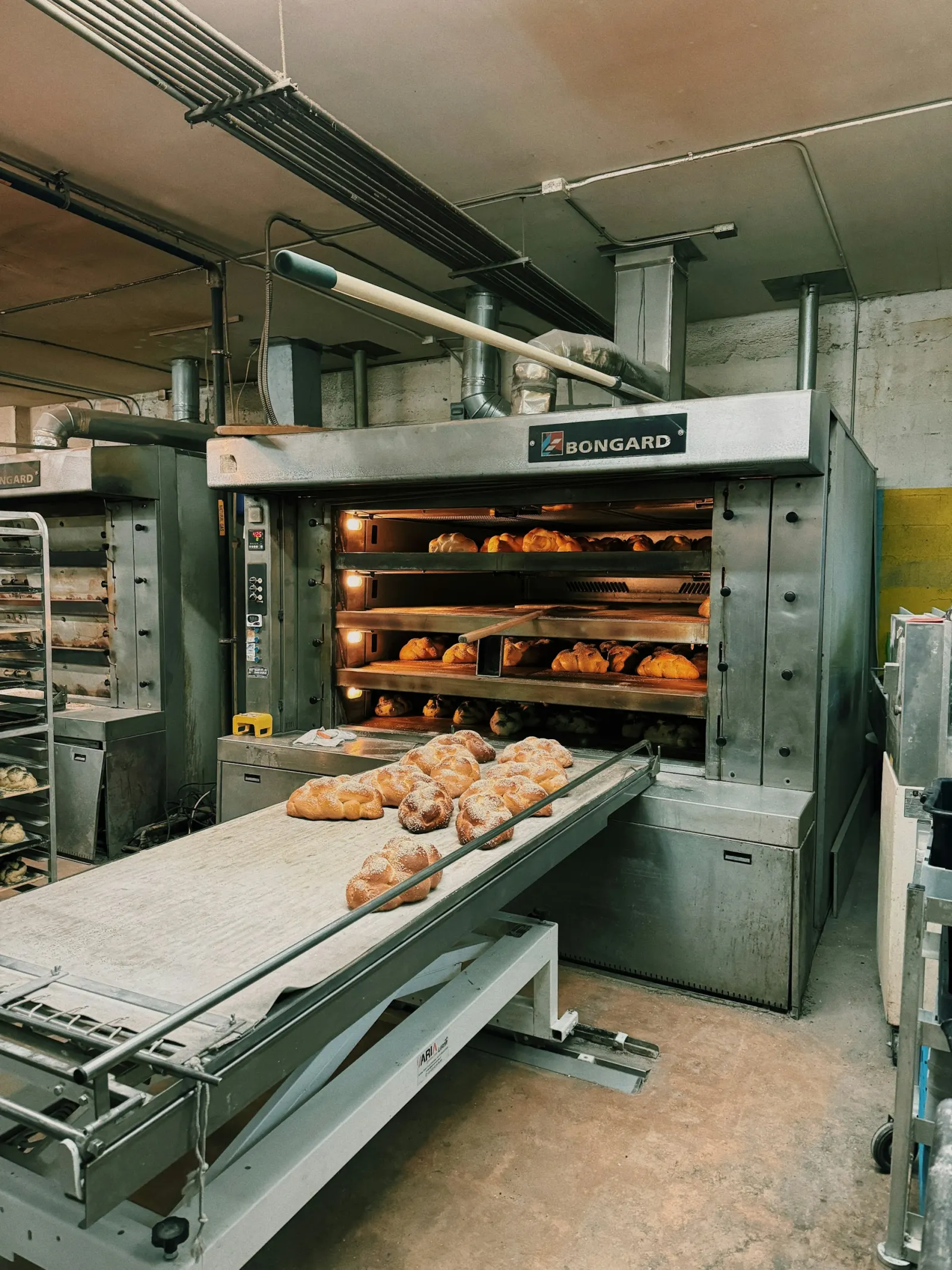 Bleche mit Backwaren vor einem Industrieofen