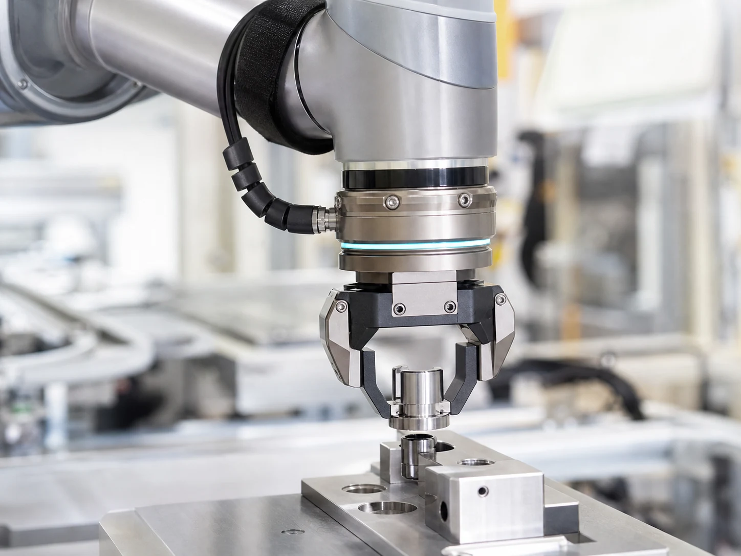 Kollaborativer Robotergreifer setzt ein Metallbauteil präzise in eine Vorrichtung ein