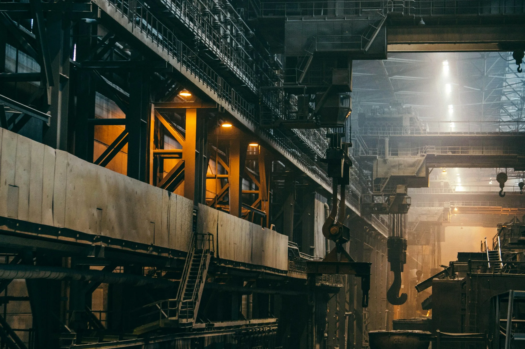 Stahlkonstruktion und Anlagen im Inneren einer Industriehalle – illustrative Aufnahme