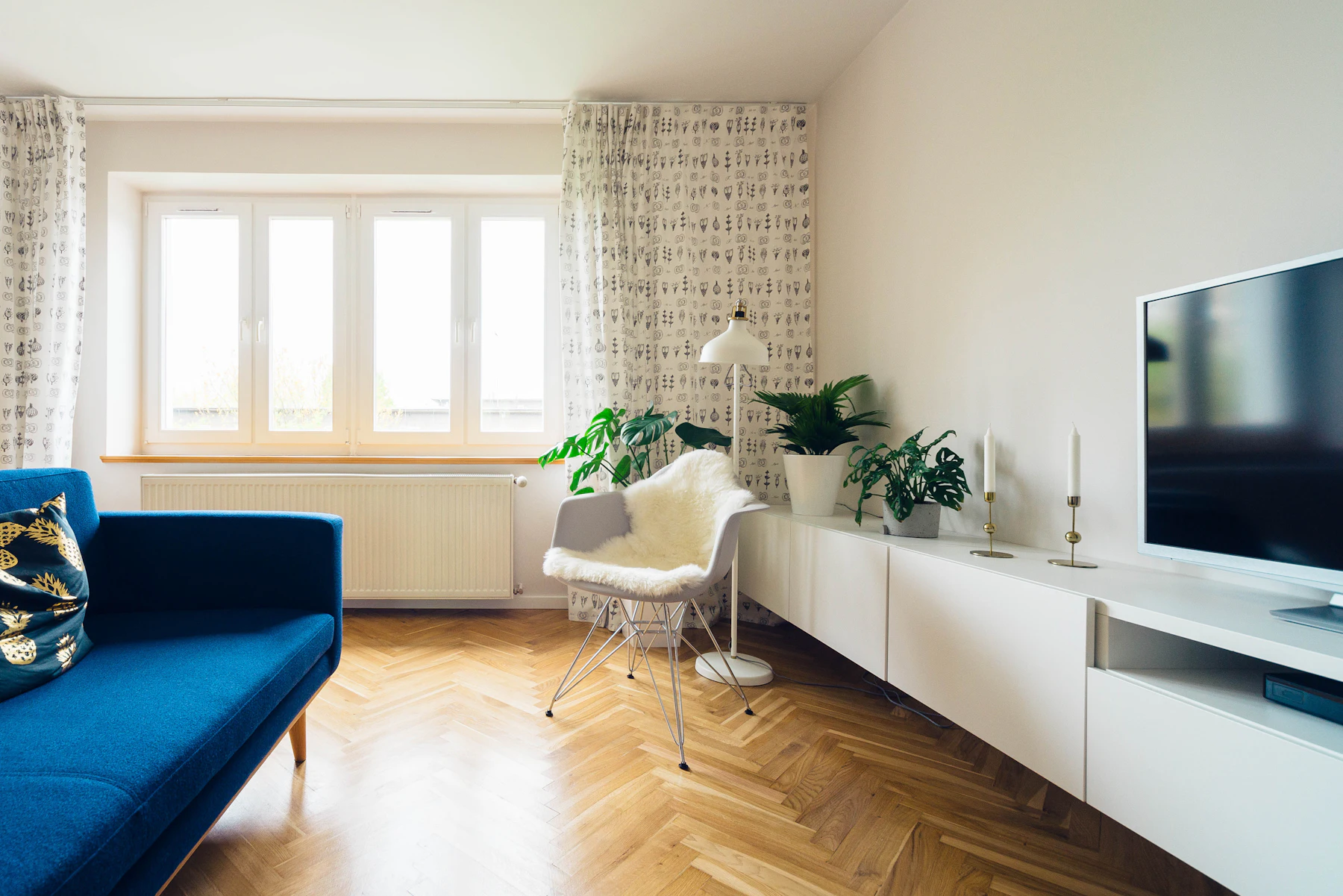 Altbauwohnung mit Fischgrätparkett, Sprossenfenstern und blauem Sofa