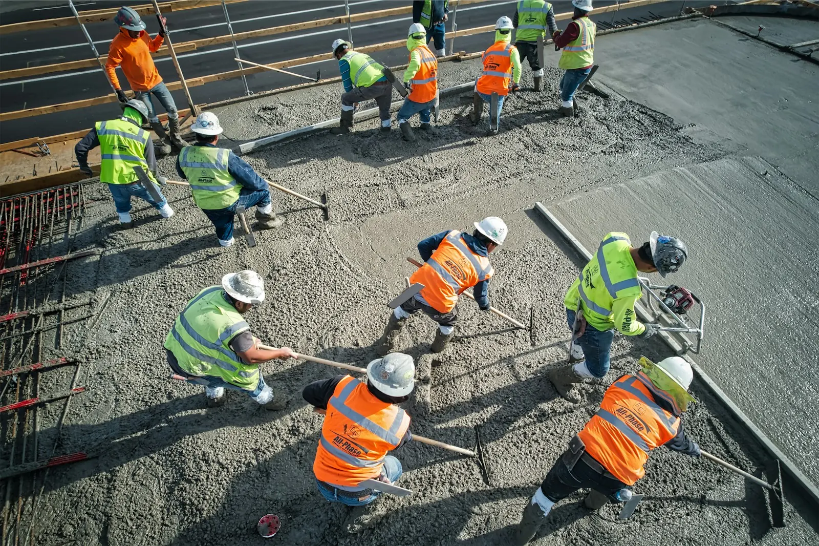 Bautrupp in Warnwesten beim Betonieren einer Fläche