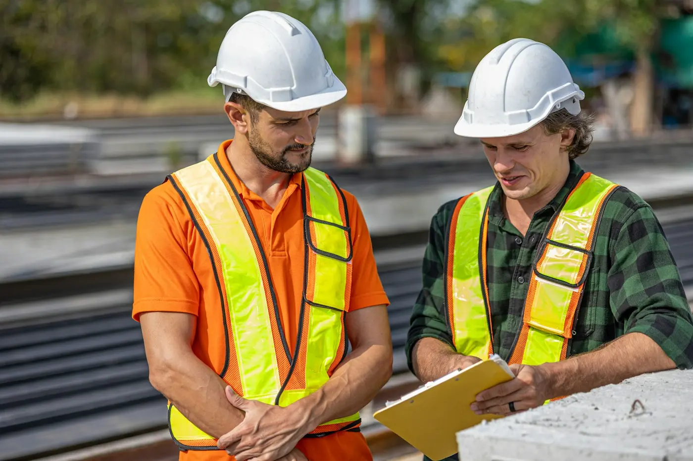 Zwei Bauleiter besprechen Pläne auf der Baustelle