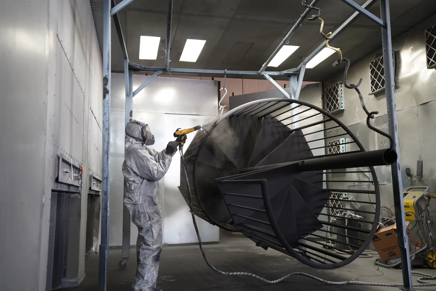 Pulverbeschichtung eines Metallbauteils in einer Werkstatt