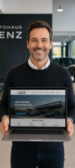 Lächelnder Mann hält einen Laptop mit einer Autohaus-Website vor einem Autohaus-Hintergrund