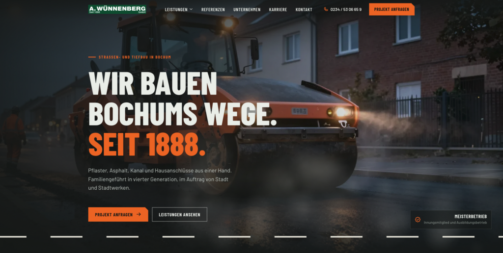 Straßenbaumaschine bei Straßenarbeiten vor Wohnhäusern mit dem Slogan „Wir bauen Bochums Wege. Seit 1888.“